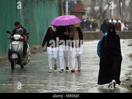 Srinagar, Jammu and Kashmir, India. 14th Mar, 2018. School girls walk as it rains in Srinagar the summer capital of Indian controlled Kashmir on March 14, 2018. Credit: Faisal Khan/ZUMA Wire/Alamy Live News Stock Photo