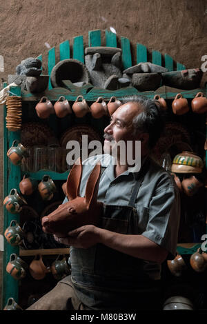 Ceramic artist Nicholas Fabian holds a traditional Purepecha design ceramic mask at his home in Santa Fe de la Laguna, Michoacan, Mexico. Stock Photo