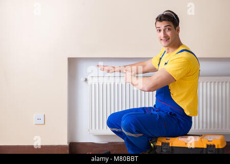 Young repairman contractor repairing heating panel Stock Photo