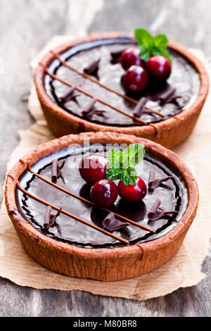 mini  chocolate tarts with cranberries on wooden background Stock Photo
