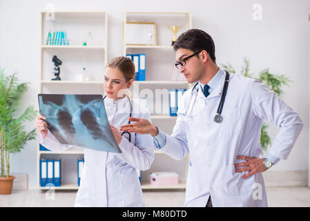 Two doctors examining x-ray images of patient for diagnosis Stock Photo