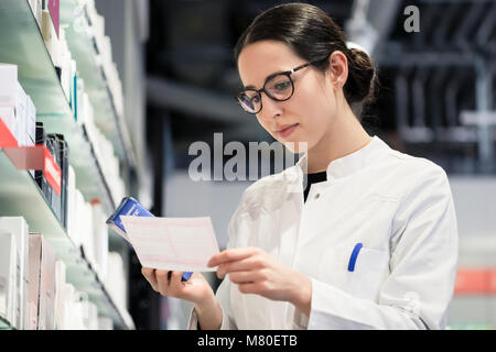 Low-angle portrait of female pharmacist checking a medical prescribtion Stock Photo