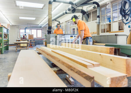 Carpenter or joiner working on logs in his workshop
