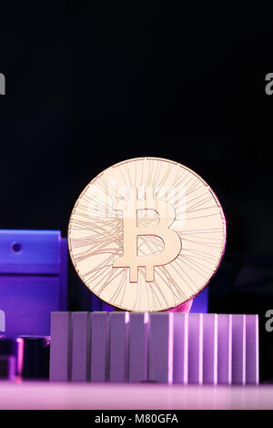 Photo of golden bitcoin and processor on pink, dark background Stock Photo