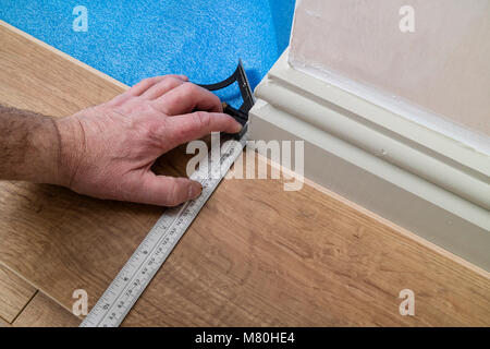 A Person Marking Out a Laminated Floor Board Using a Combination Set Square to Mark Out a Corner, UK. Stock Photo