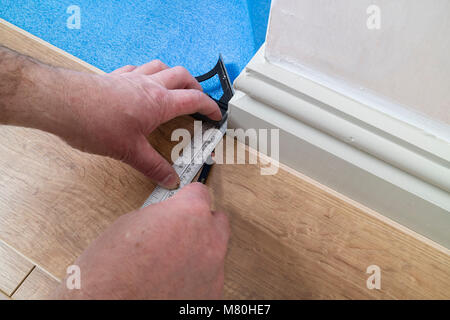 A Person Marking Out a Laminated Floor Board Using a Combination Set Square to Mark Out a Corner, UK. Stock Photo