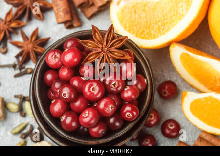 Ingredients for cooking traditional spicy winter drinks - cranberry, citrus, cinnamon, cardamom, star anise, cloves, pepper. Non-alcoholic mulled wine Stock Photo