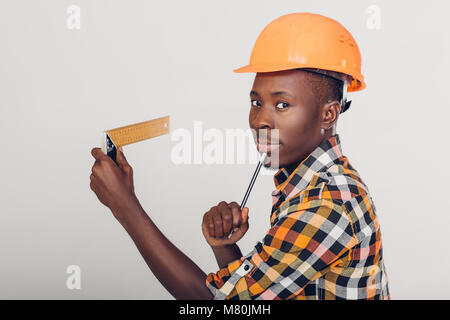 African-American builder uses measuring tape Stock Photo