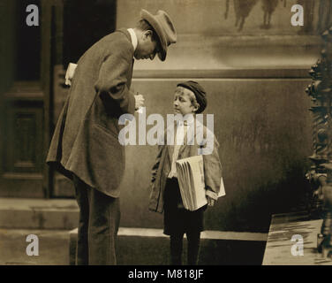 Michael McNelis, 8-year-old Newsboy, just recovering from Pneumonia, found Selling Papers in Rain Storm at time of photo, Portrait with Adult Man, Philadelphia, Pennsylvania, USA, Lewis Hine for National Child Labor Committee,  June 1910 Stock Photo