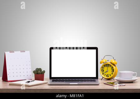 Modern laptop computer, Coffee cup, alarm clock, notebook and calendar on wooden table. Studio shot isolated on white background. Blank screen for gra Stock Photo