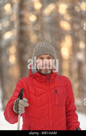 Mature man in red jacket cross-country skiing Stock Photo