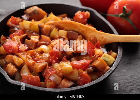 Ratatouille in an iron pan on a rustic table Stock Photo