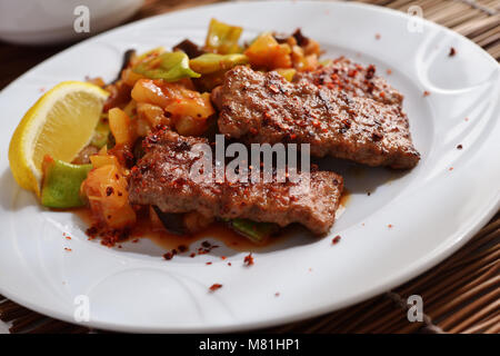 Adana kofte with roasted vegetables and lemon Stock Photo