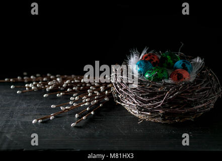 Multi-colored eggs on a dark background. Easter still life in a low key. Dark rustic background with copy space Stock Photo
