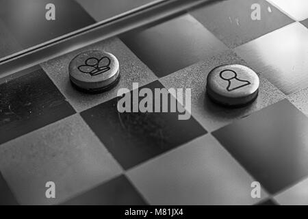 Monochrome Photo with a picture of a chess steel Board and chess pieces, Metal chess pieces on a chess Board with reflection. Stock Photo