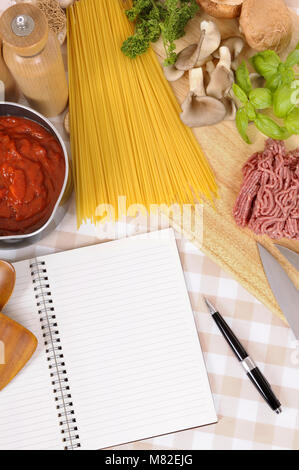 Making Italian spaghetti bolognese with ingredients and blank recipe book or cookbook. Space for copy. Stock Photo