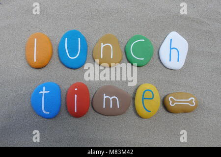 Lunch time, conceptual multicolored stones composition over beach sand Stock Photo
