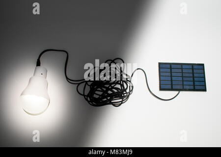Solar panel, photovoltaic, alternative electricity source - concept of sustainable resources and connected light bulb Stock Photo
