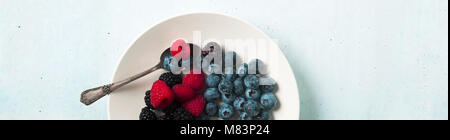 Fruit salad with Various fresh summer berries in white plate . Top view Stock Photo