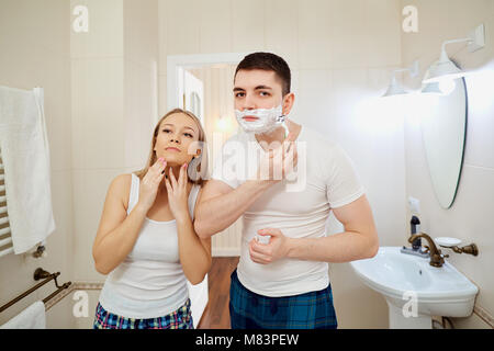 Couple in the morning in the bathroom doing personal hygiene. Romantic morning together. Stock Photo