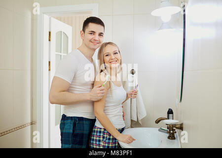 Couple in the morning in the bathroom doing personal hygiene. Romantic morning together. Stock Photo
