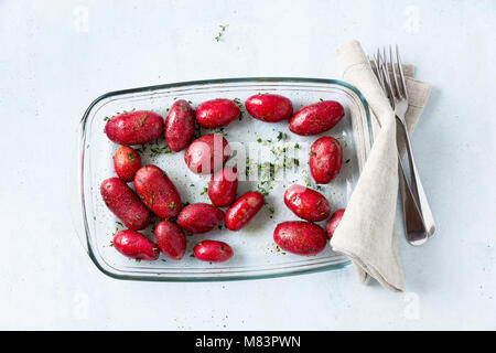 raw red potatoes in oil with spices on a resistant oven tray or Glass Oven Dish, ready to be baked in the oven Stock Photo