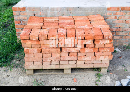 The red brick folded neatly on the foundation of the house. Home construction Stock Photo