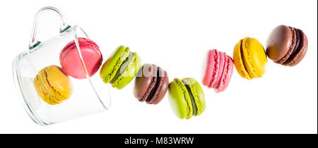 colorful traditional French sweets macaroons from almond flour isolated on white. and an empty tea cup. objects in motion Stock Photo