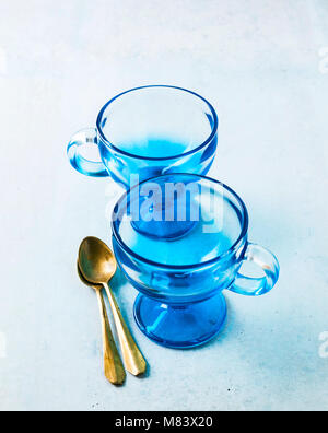 two empty glass blue ice cream cups and spoons on the table. Stock Photo