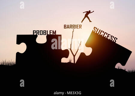man jumping over jigsaw opposite success shore, concept as can solve  problem, barrier , belive and faith to conncet business Stock Photo