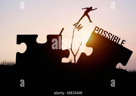 man jumping over jigsaw opposite possible shore, concept as  believe and faith to conncet business Stock Photo