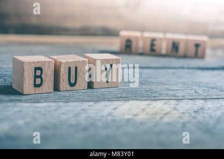 Macro Of The Words Buy And Rent Formed By Wooden Blocks On A Wooden Floor Stock Photo