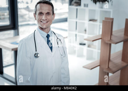 Satisfied responsible medic being in the cabinet and looking straight. Stock Photo