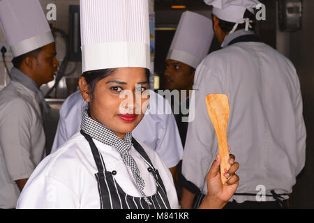 Female chef holding a wooden spatula Stock Photo