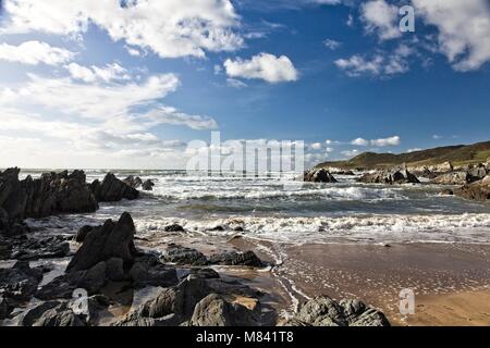 ROCKS, RISING TIDE, WAVES AND MORTE POINT FROM BARRICANE BEACH WOOLACOMBE DEVON ENGLAND Stock Photo