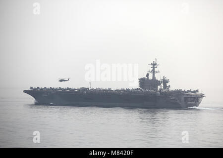 U.S Navy nuclear powered super carrier USS Dwight D. Eisenhower sails in the Arabian Gulf in foggy conditions Stock Photo