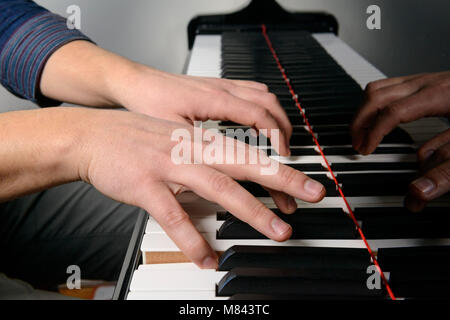 Close up of hands playing piano Stock Photo