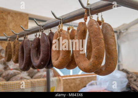 Iberian chorizo sausages hanging on market stall Stock Photo