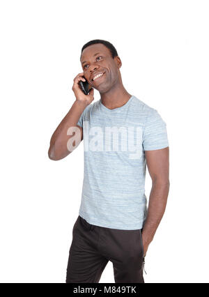 An handsome African American man standing in a gray t-shirt  talking at his cell phone and smiles, isolated for white background Stock Photo