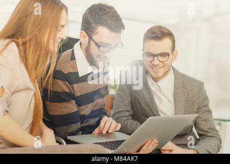 friendly business team working on laptop and discussing business matters Stock Photo