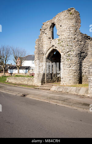 Gatehouse of medieval Barry castle ruin situated  beside a suburban road lit by early morning sunshine under a clear blue sky Stock Photo