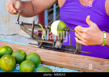 Man in Cuba Peeling Oranges with a Manual Peeler Stock Photo