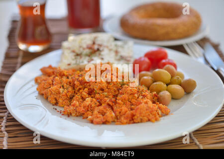 Turkish breakfast with menemen, cheese, vegetables, simit, and tea Stock Photo