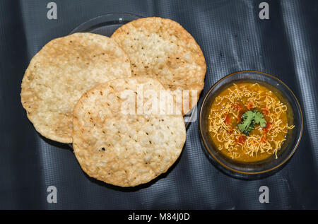 Dal Pakwan - The famous Sindhi cuisine- crispy deep fried flat bread with cooked spiced lentils (chanadal), mint chutney, tamarind-date chutney and on Stock Photo