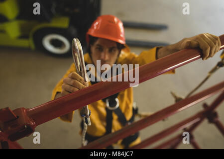 Male worker climbing scaffolding at solar station Stock Photo