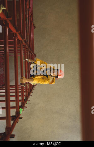 Male worker climbing scaffolding at solar station Stock Photo