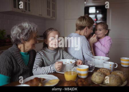 Multi-generation family having breakfast in kitchen Stock Photo