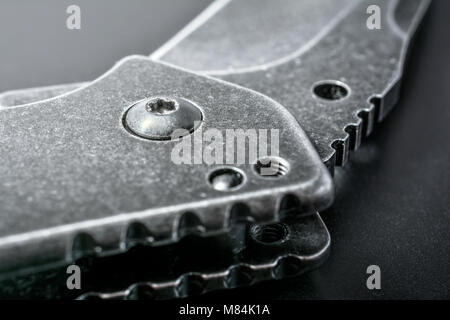 Close Up Of A Half Open Black Folding Knife On Dark Ground Stock Photo
