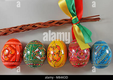 Traditional czech Wicker whip and easter eggs in row. Traditional Czech easter decoration. Stock Photo
