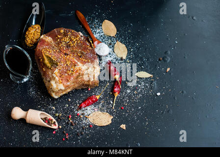 pork meat marinated in salt and spices on the board with grains of mustard, pepper, top view Stock Photo